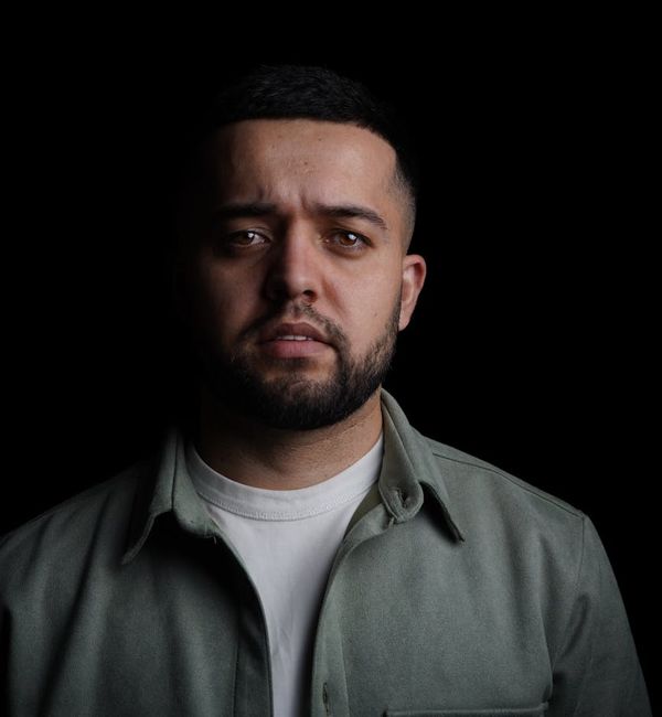 Man in a powerful and energetic pose against a dark background.